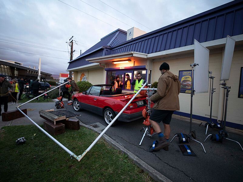 A car gowing through a drive-thru being filmed from behind