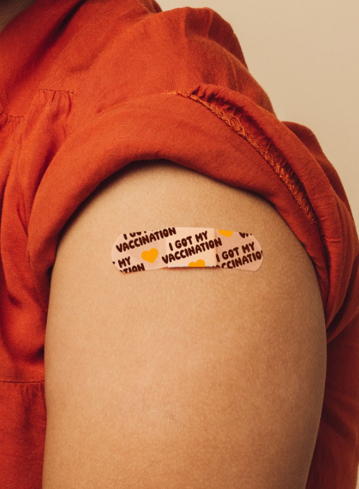 A person wearing a bandaid on their upper arm