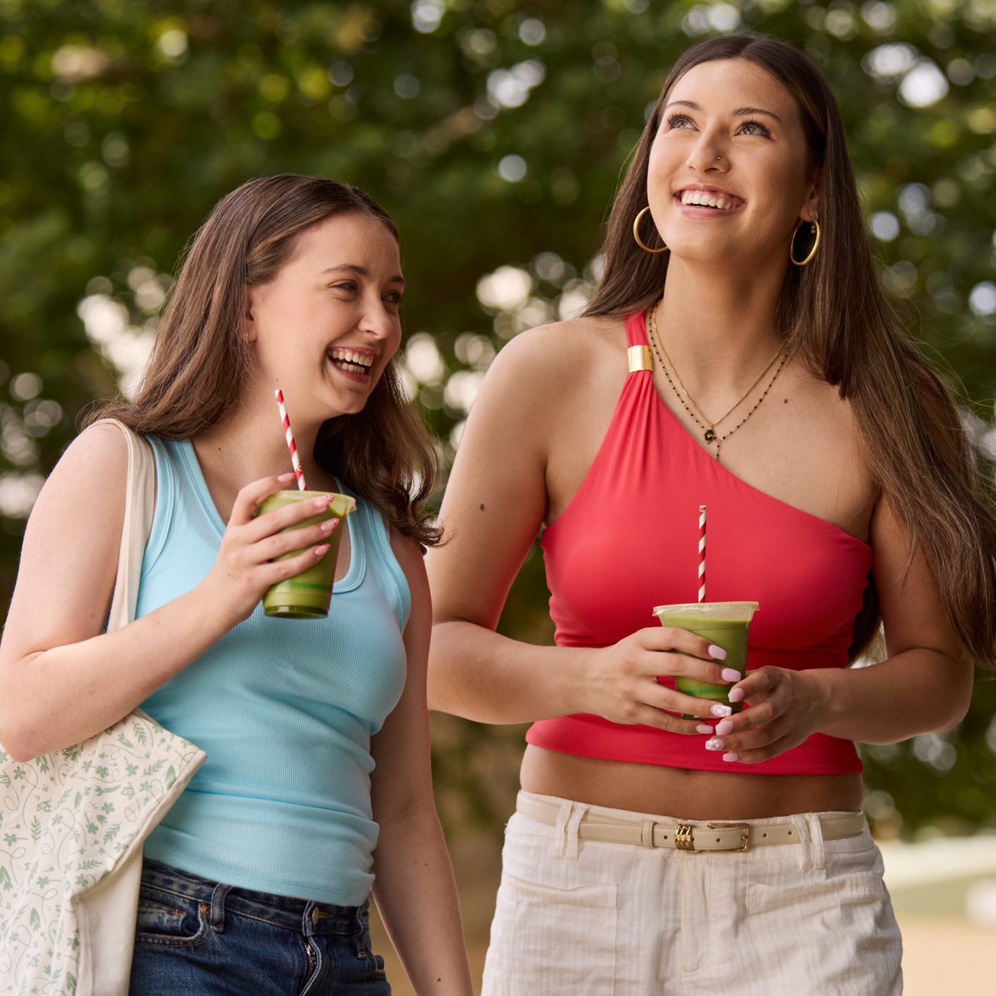 two people walking with matcha drinks outside