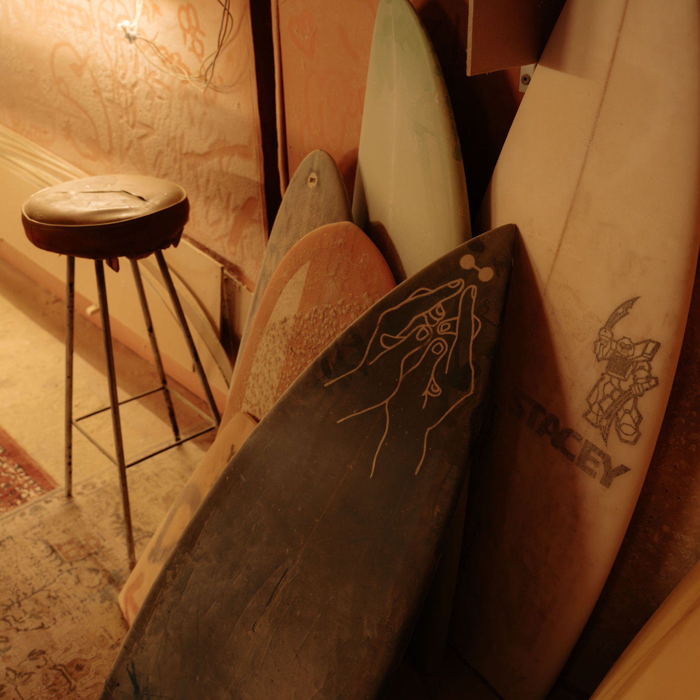Surfboards resting inside a beach shelter overlooking the coast.