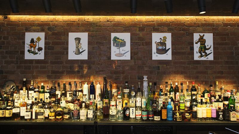 Wide shot of a bar with bottles of alcohol