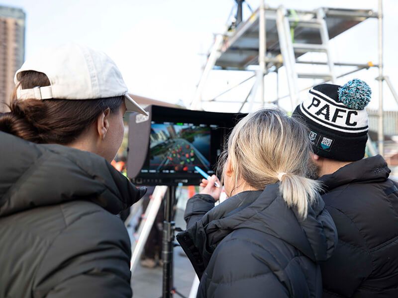 Fuller team looking at the camera screen on set
