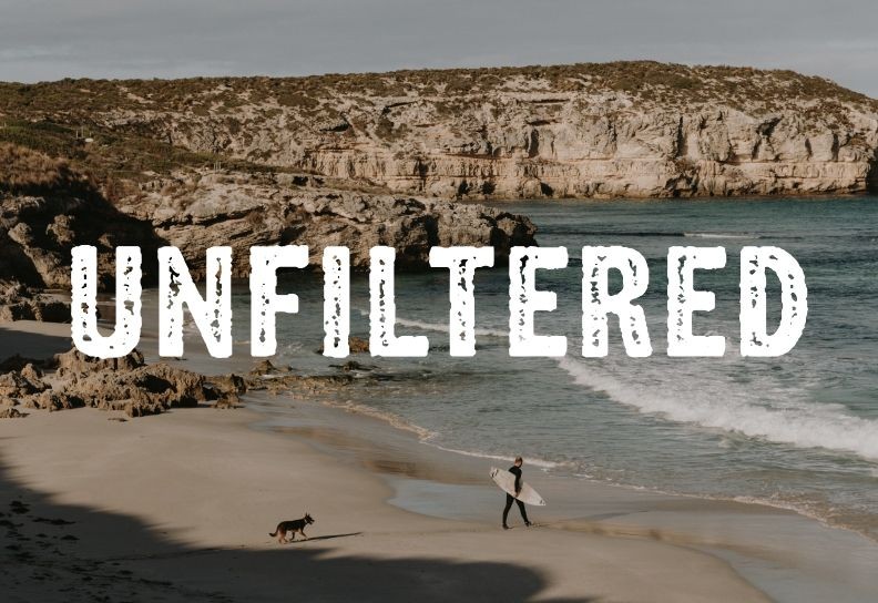 Kangaroo Island “Unfiltered” campaign hero artwork featuring a surfer and dog walking along a remote beach.