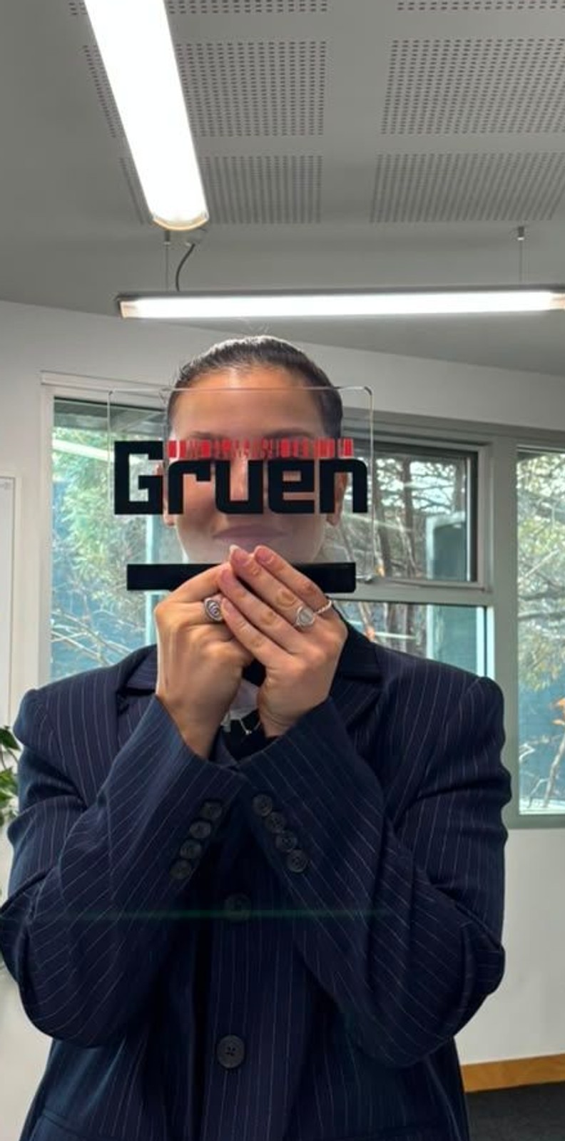 Lana holding the Gruen trophy in front of her face