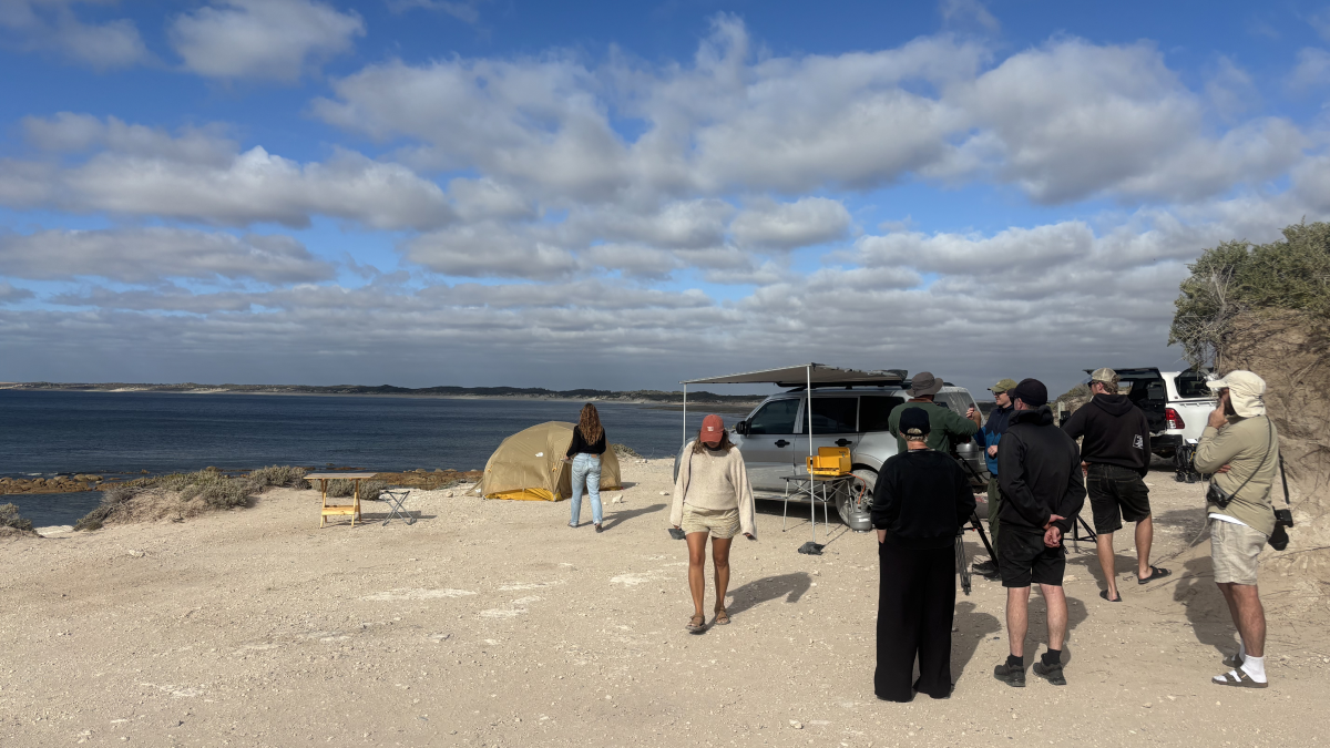 Behind-the-scenes filming of a beachside dining scene for “The Coast is Calling” campaign.