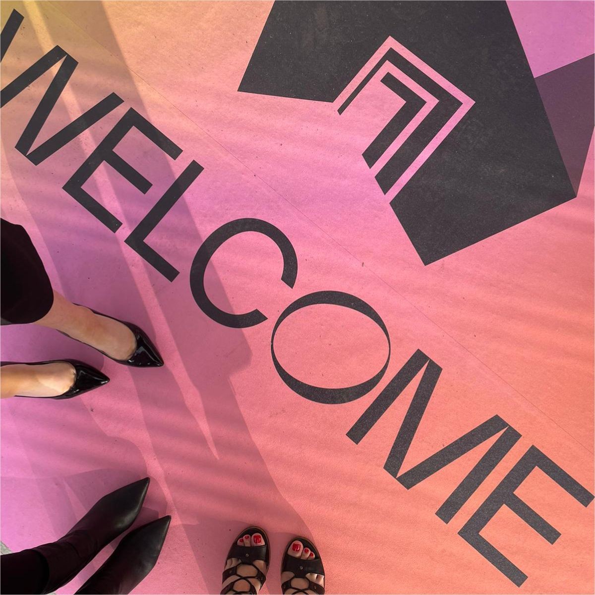 Downward shot to floor showing new state of mind logo and surrounded by peoples feet