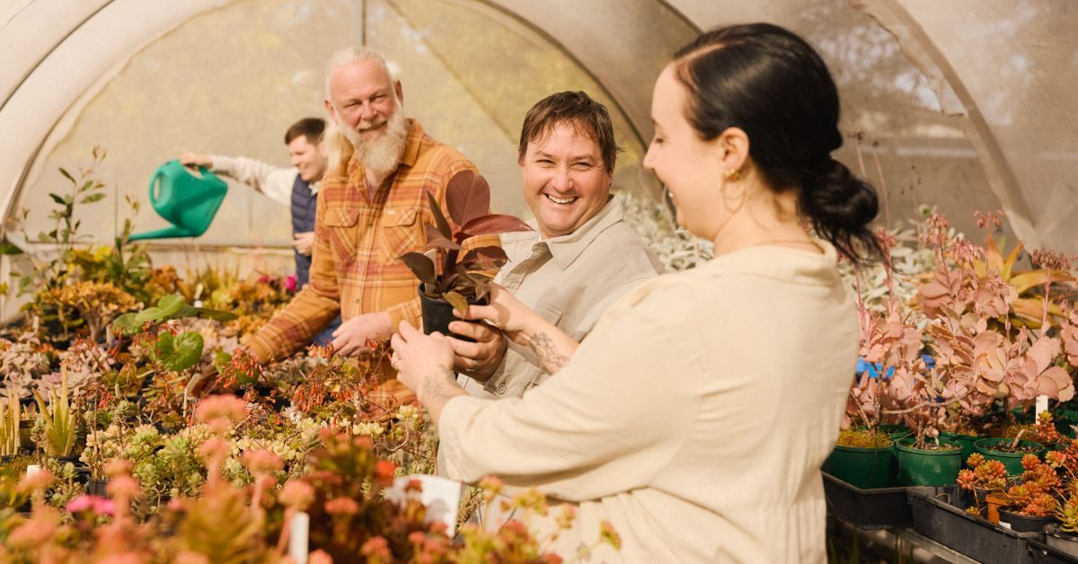 Four people enjoying a social gardening activity together.