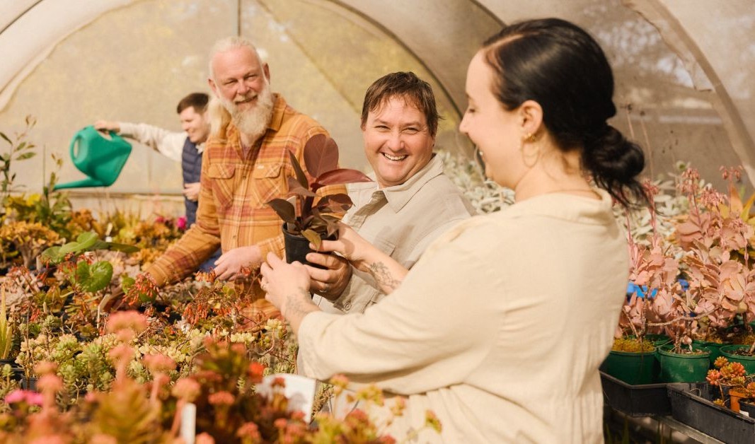 Four people enjoying a social gardening activity together.