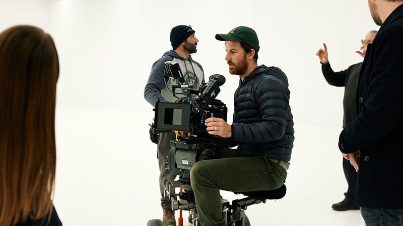 A videographer and crew on a film stage