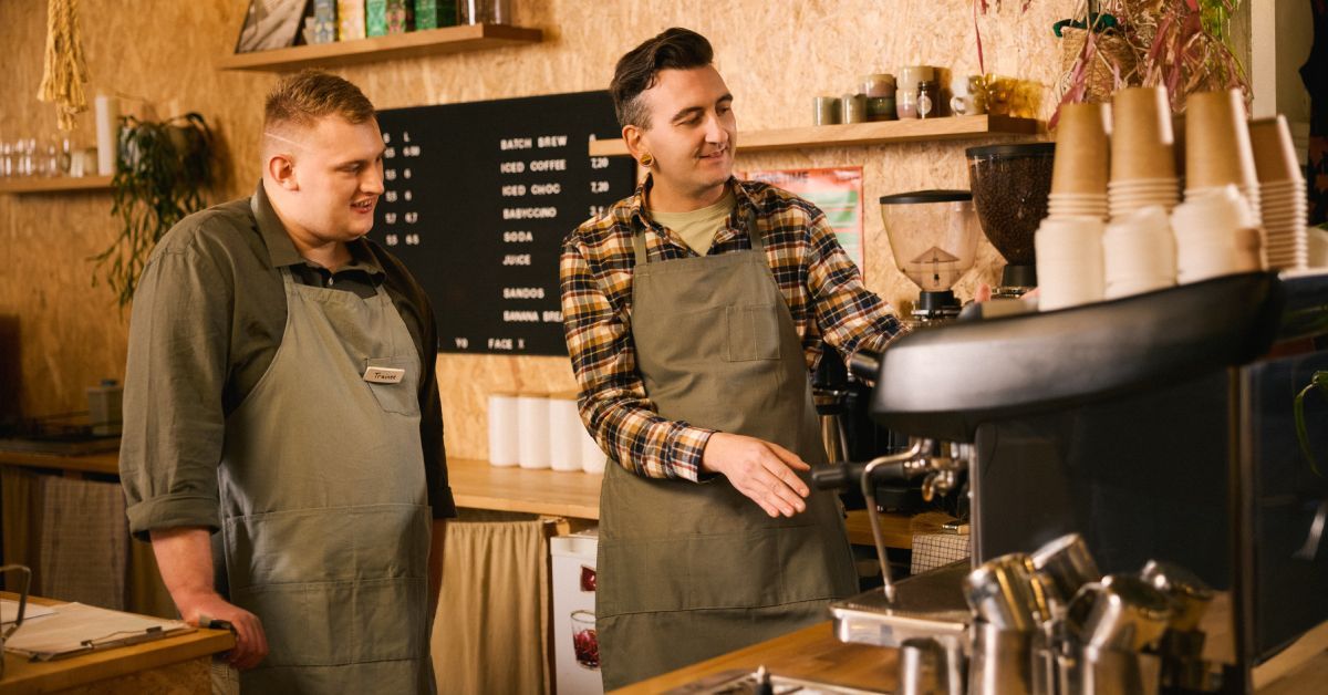 Two people working behind the counter at a café.