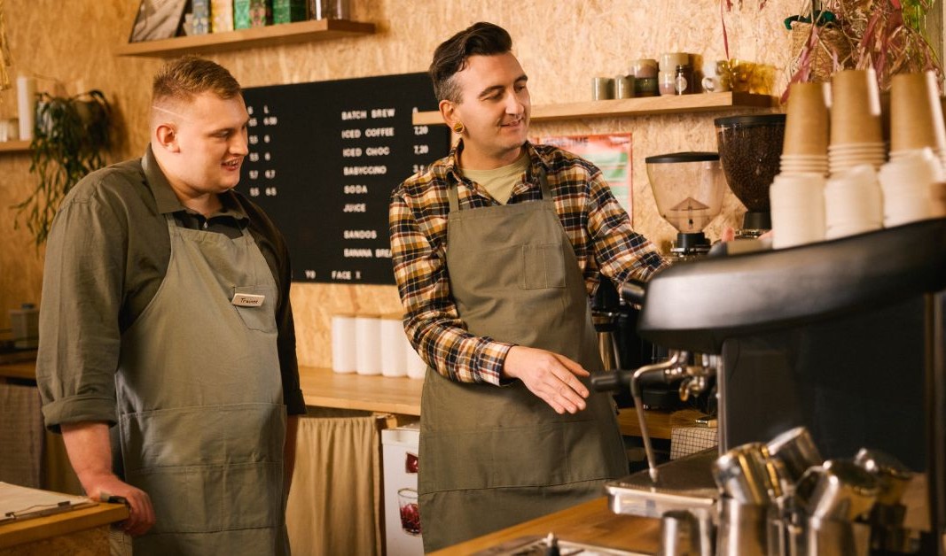 Two people working behind the counter at a café.