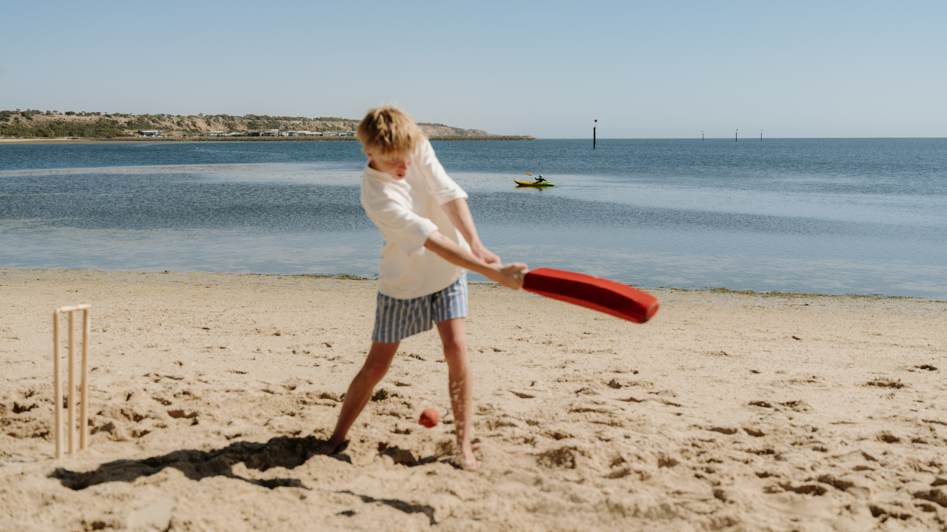 Child playing cricket on a South Australian beach.