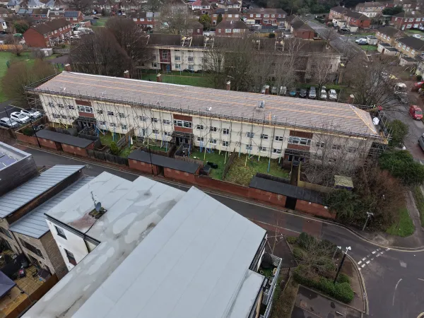 Oblique drone view of a scaffolded Fernside Close residential block with roof membrane and battens installed during renewal works.
