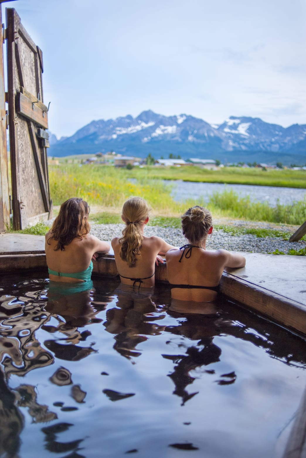 group soaking in hot springs on way to Stanley, ID with a mountain view | Stanley chamber