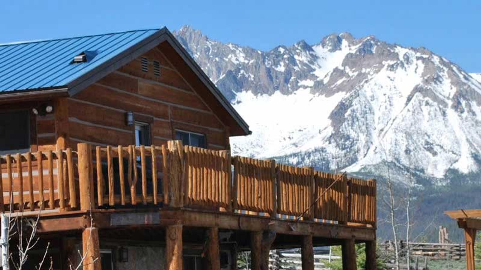 A raised cabin with beautiful mountains in the background