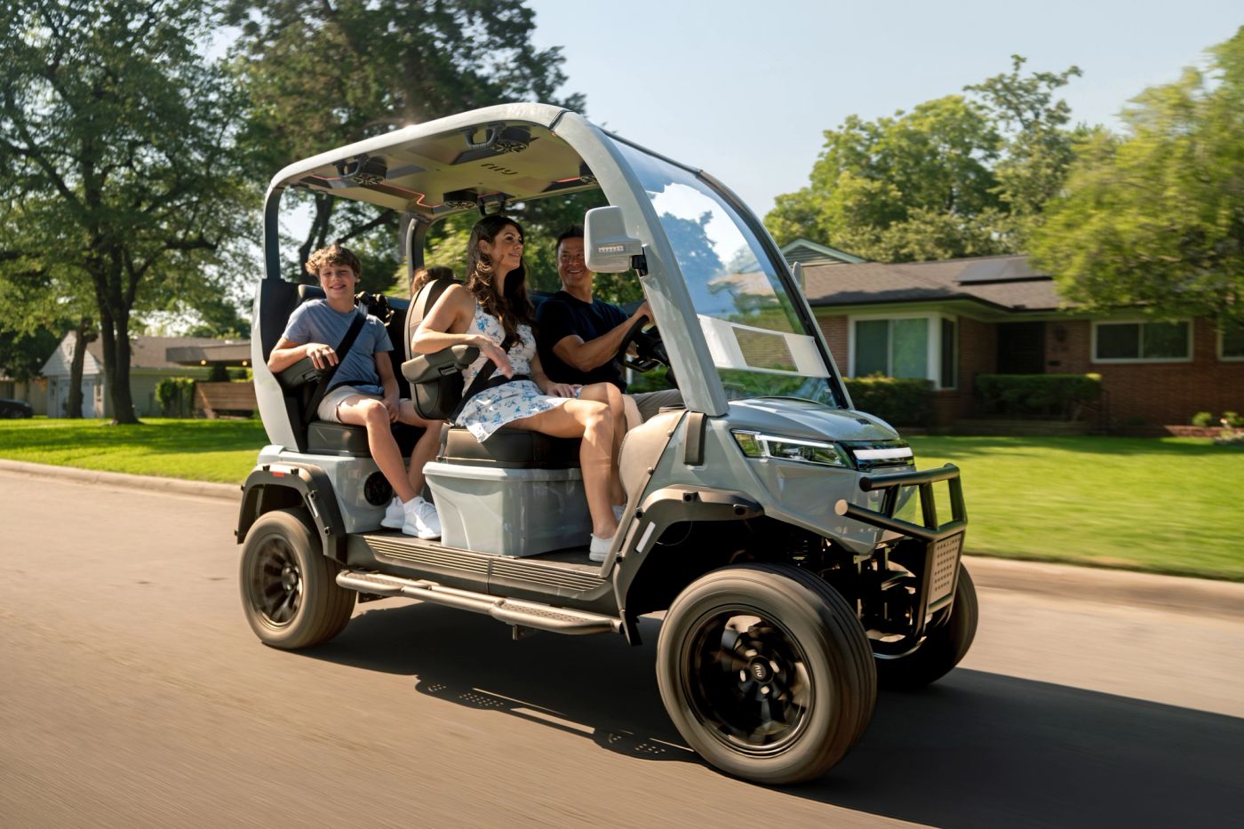 Four people driving the NIUGT through a residential neighborhood