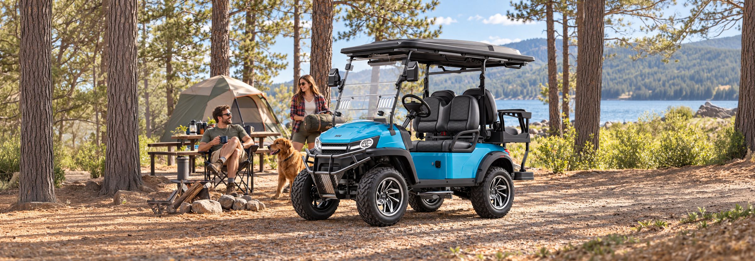 Blue NIU MT parked beside a tent at a pine-forest campsite, a couple and their dog resting at the picnic table.