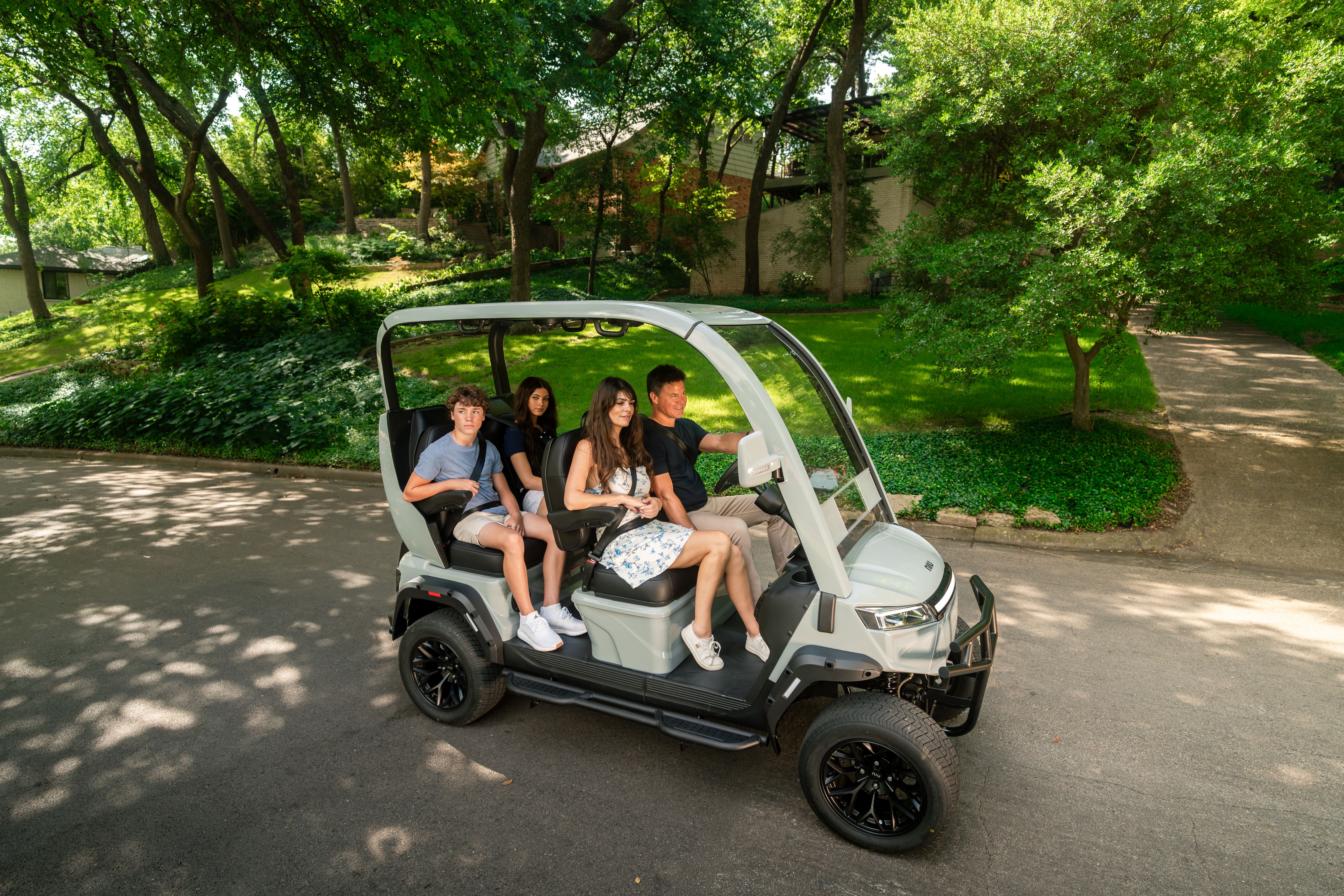 Four passengers seated in the NIUGT in a park