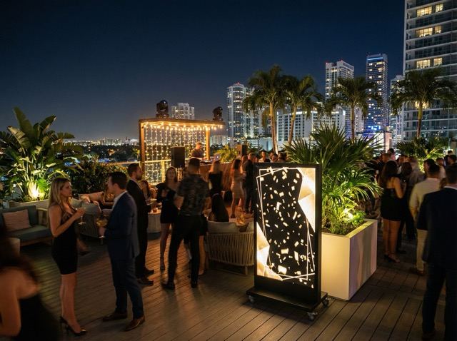Freestanding LED displays showing guest messaging at a rooftop event.