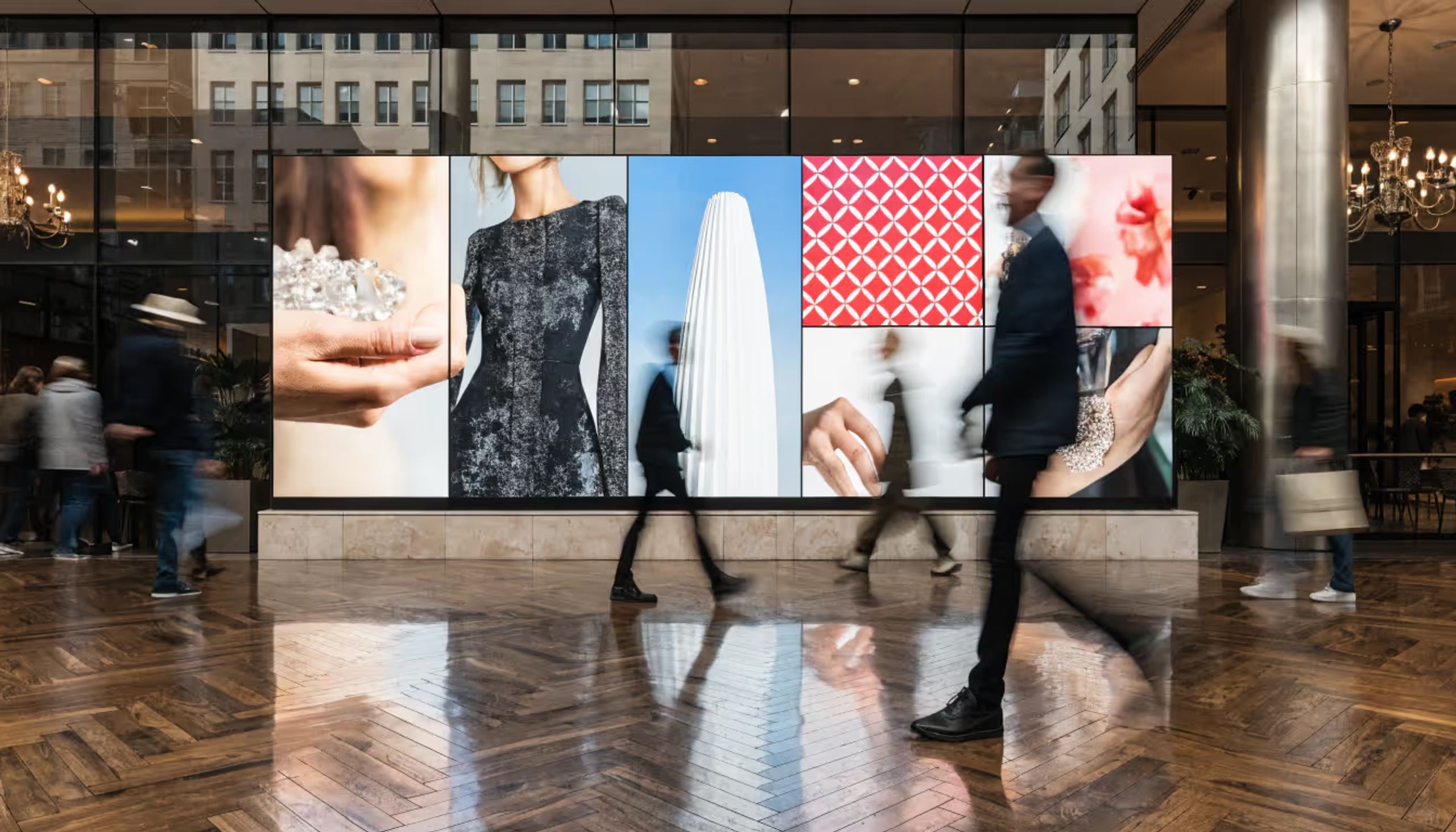 LED video walls flanking the reception desk of a hotel lobby.
