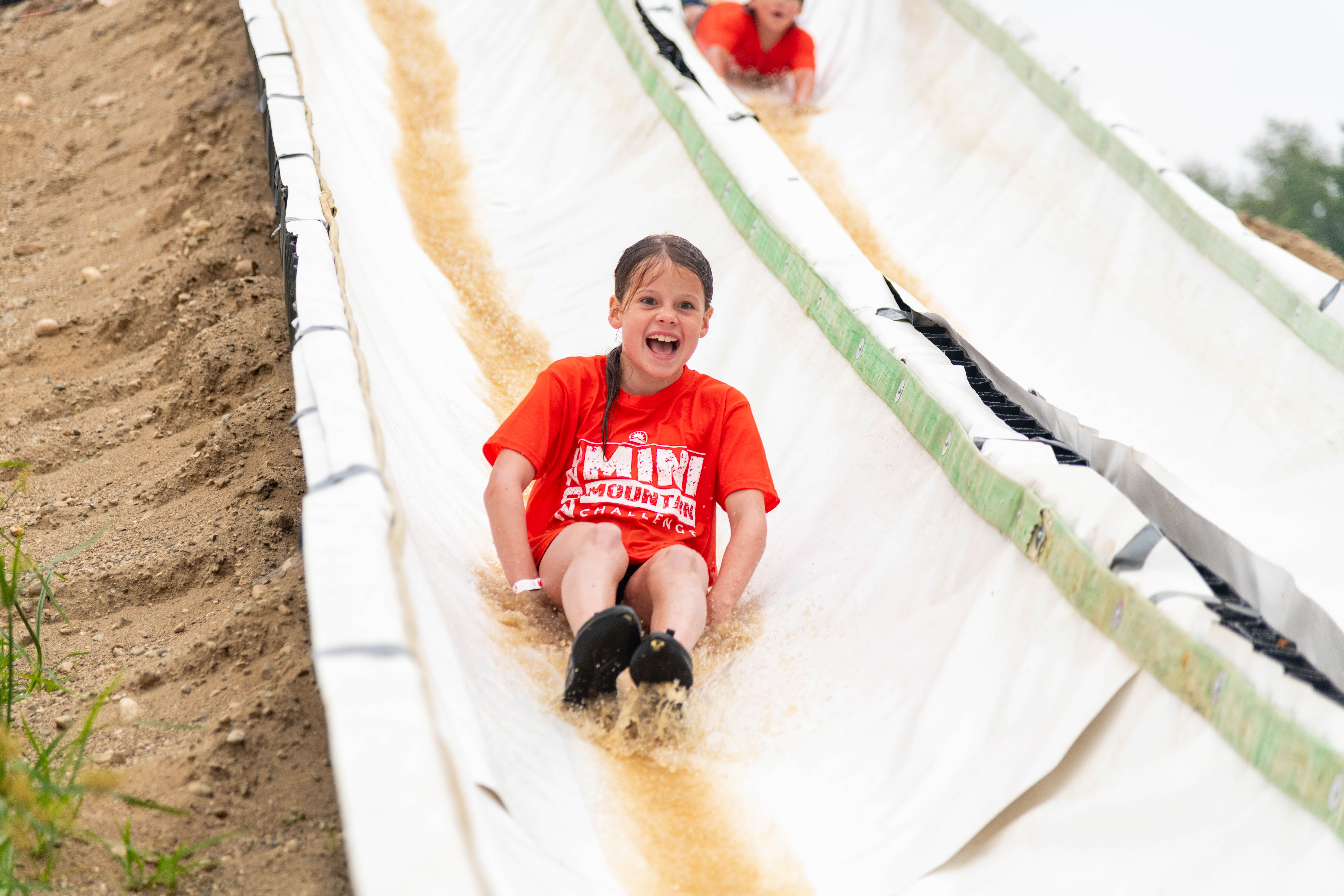 A young girl going down the water slide.