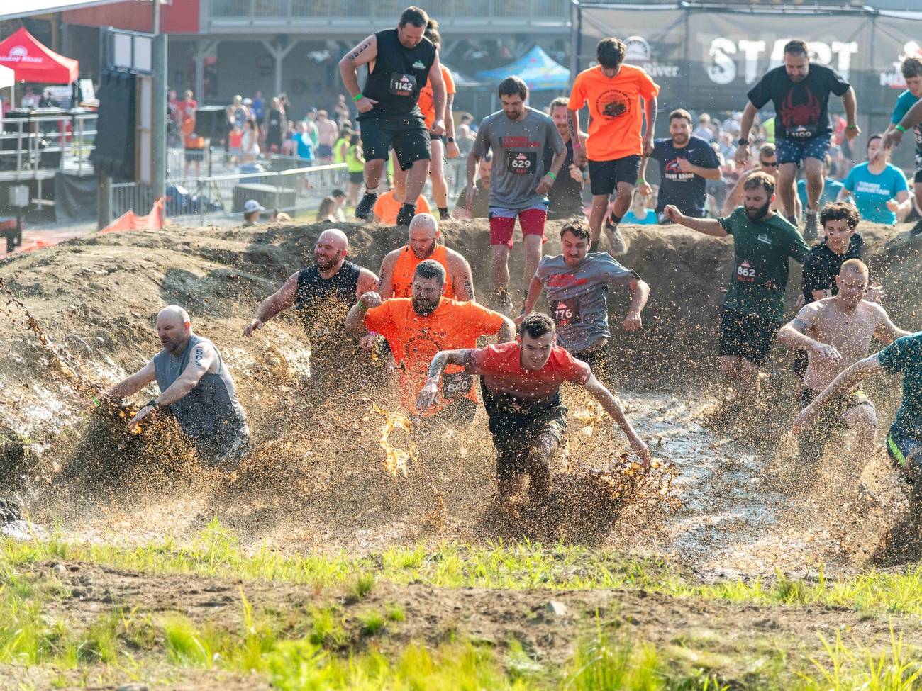 Tough Mountain Competitors running through mud.
