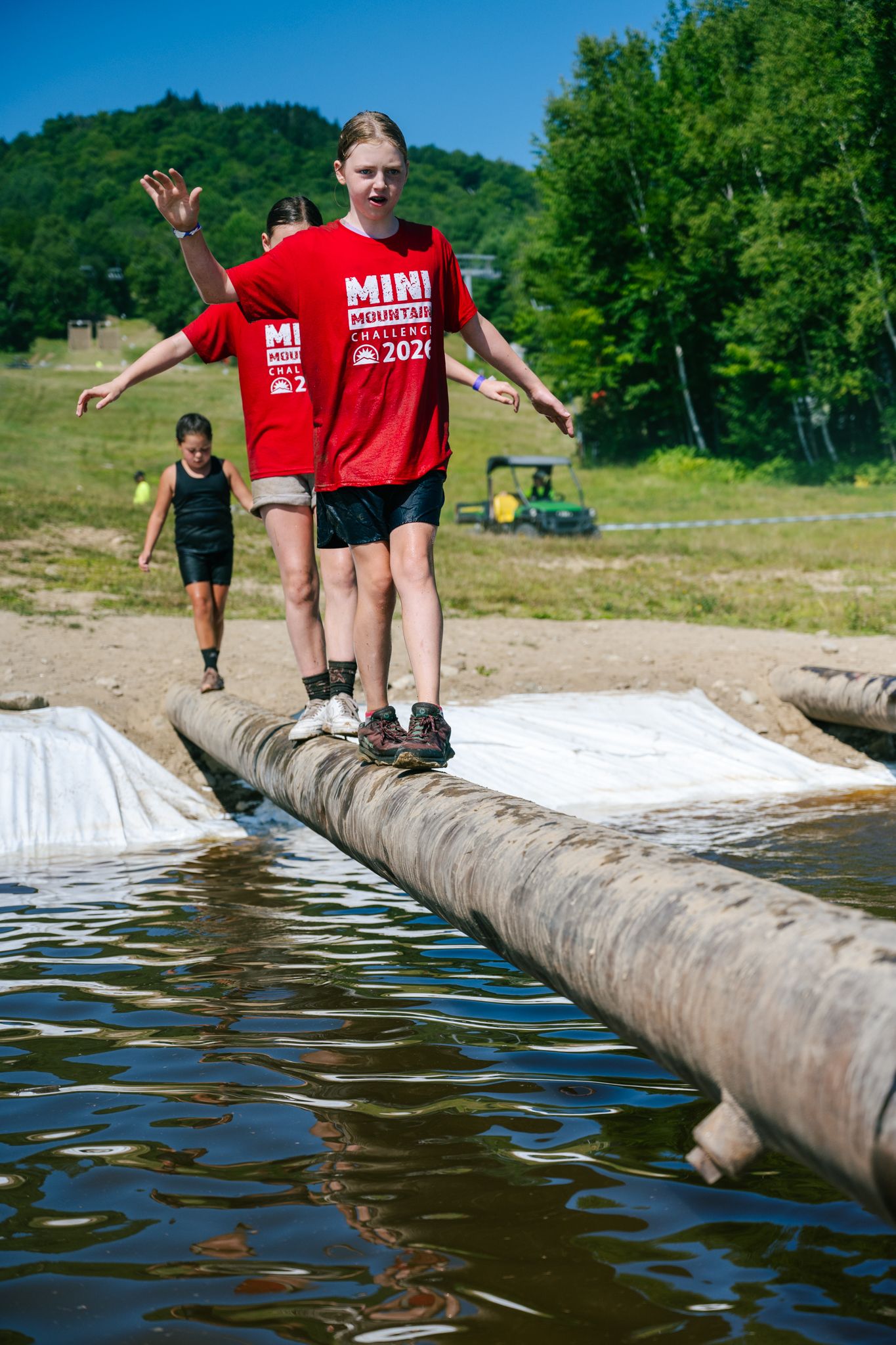 Mini Mountain Challenge competitors walking across a balance beam.