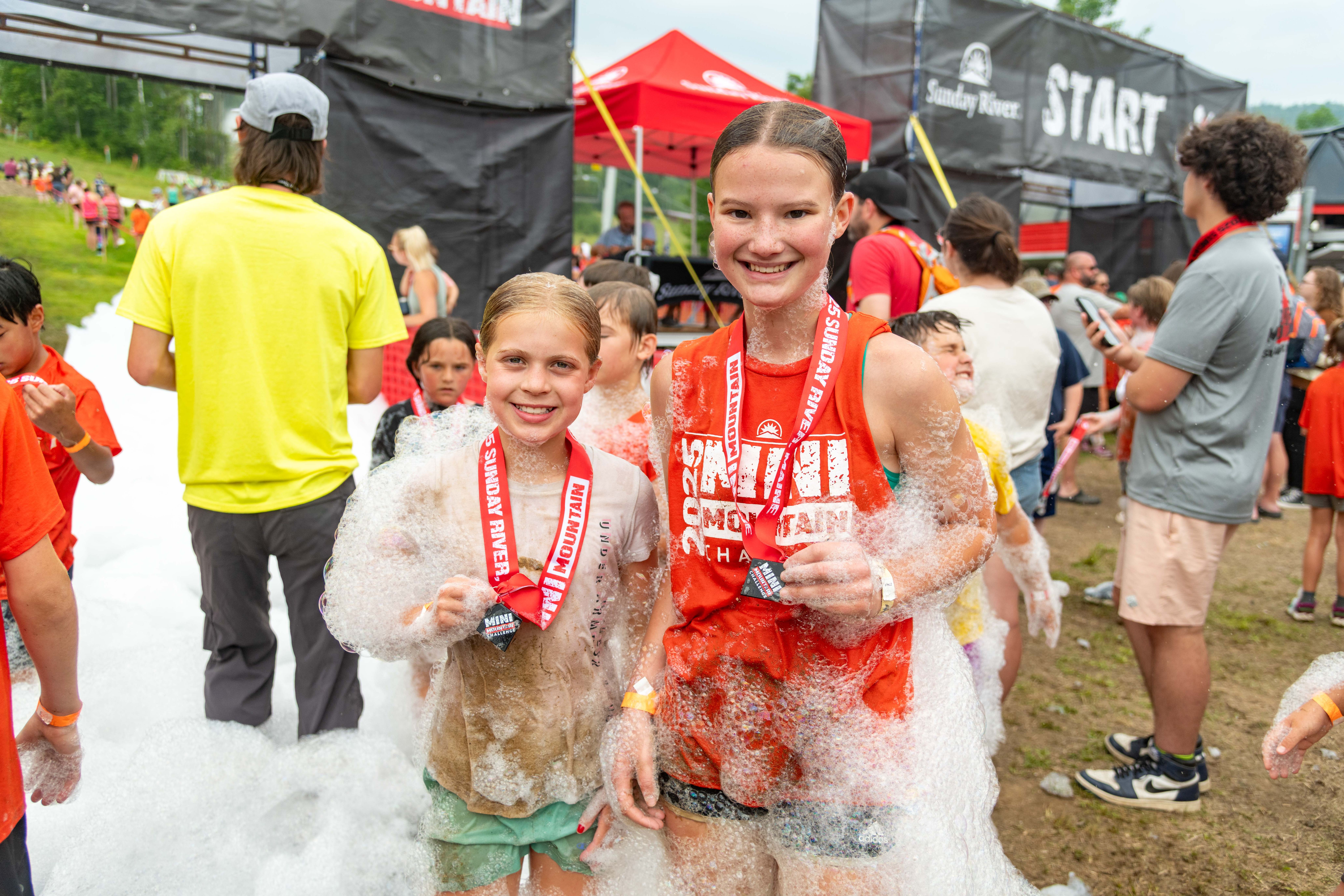 Two racers holding their medals after the Mini Mountain Challenge.