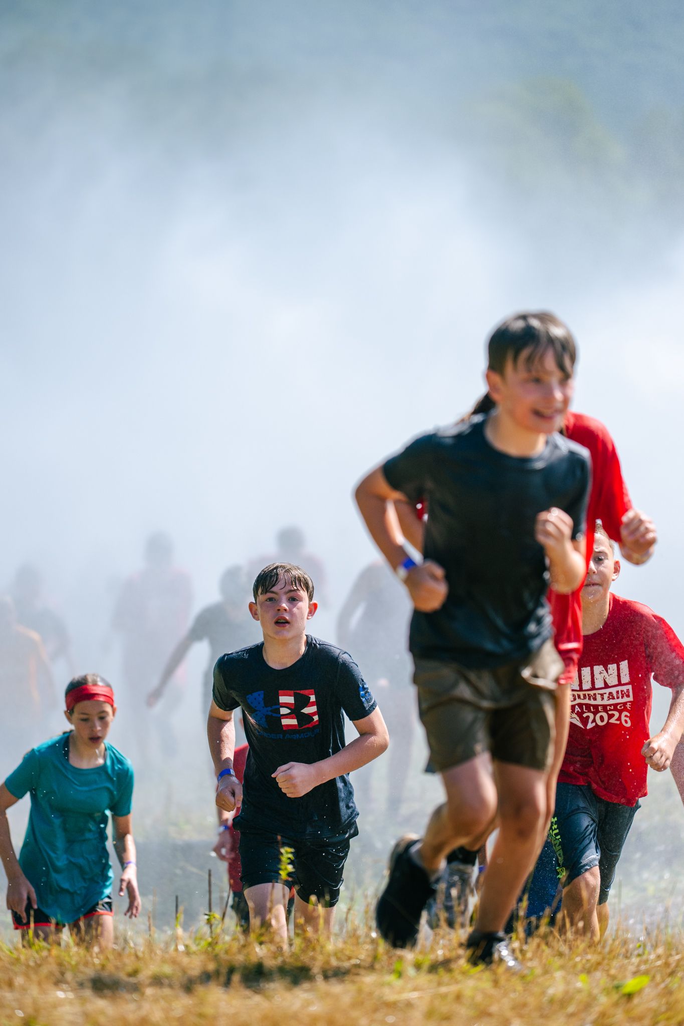 Mini Mountain Challenge racers splashing through mud.