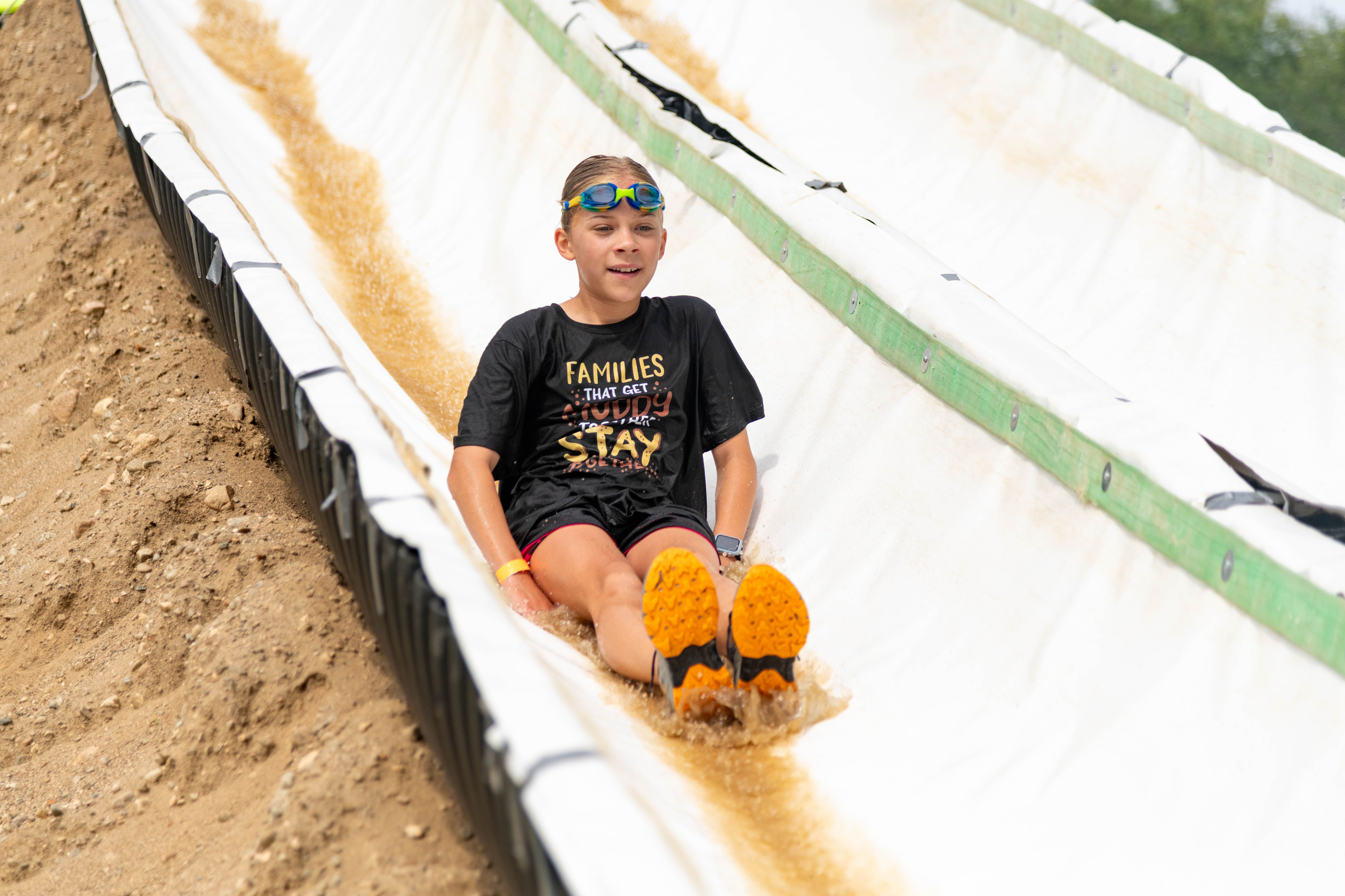 Mini Mountain Challenge competitor on the waterslide obstacle.