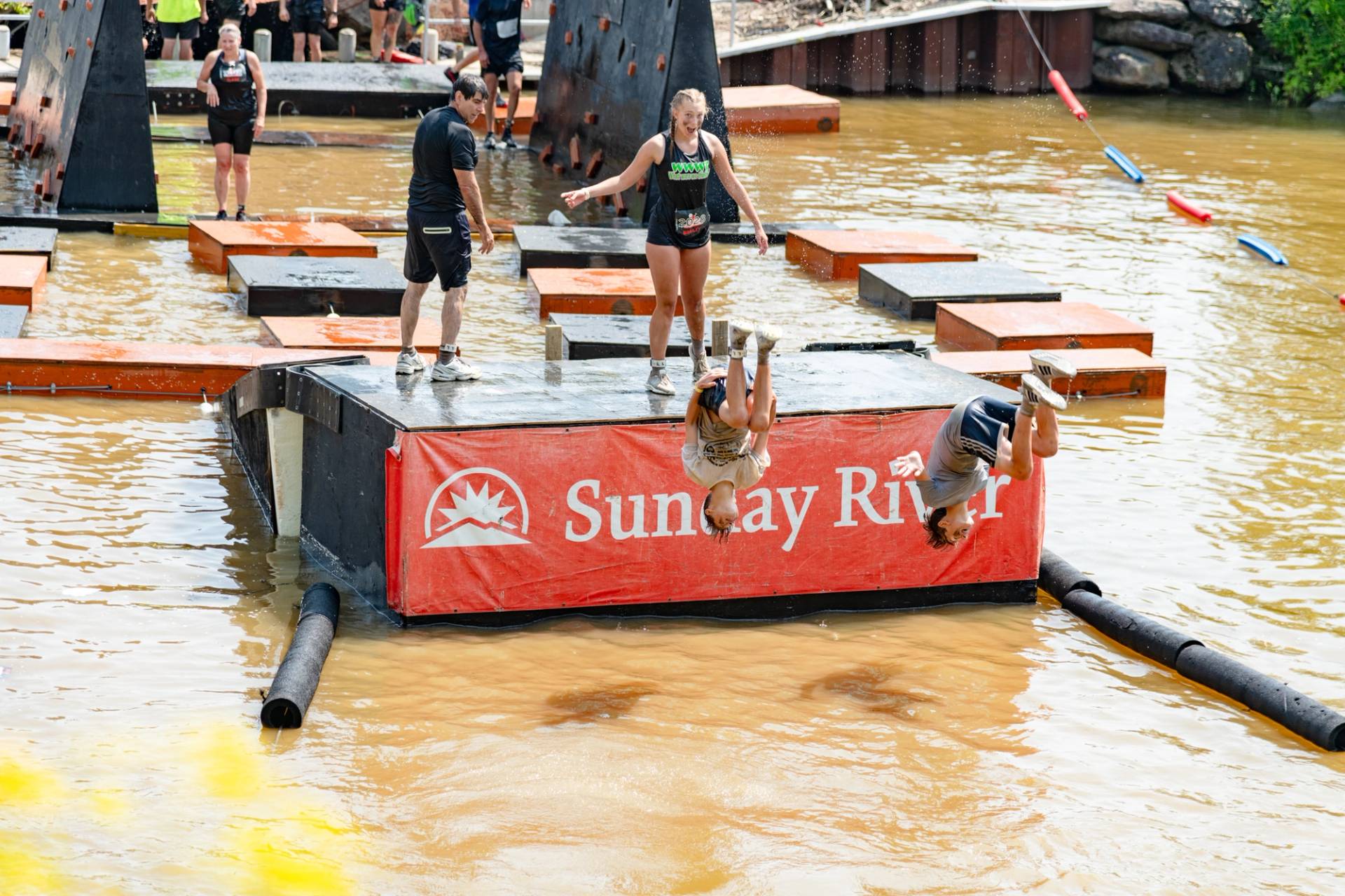 People running through a mud pit at Sunday River's Tough Mountain Challenge.