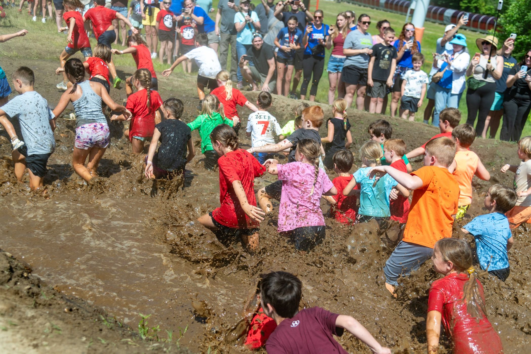 Young competitors going through a whole bunch of mud.