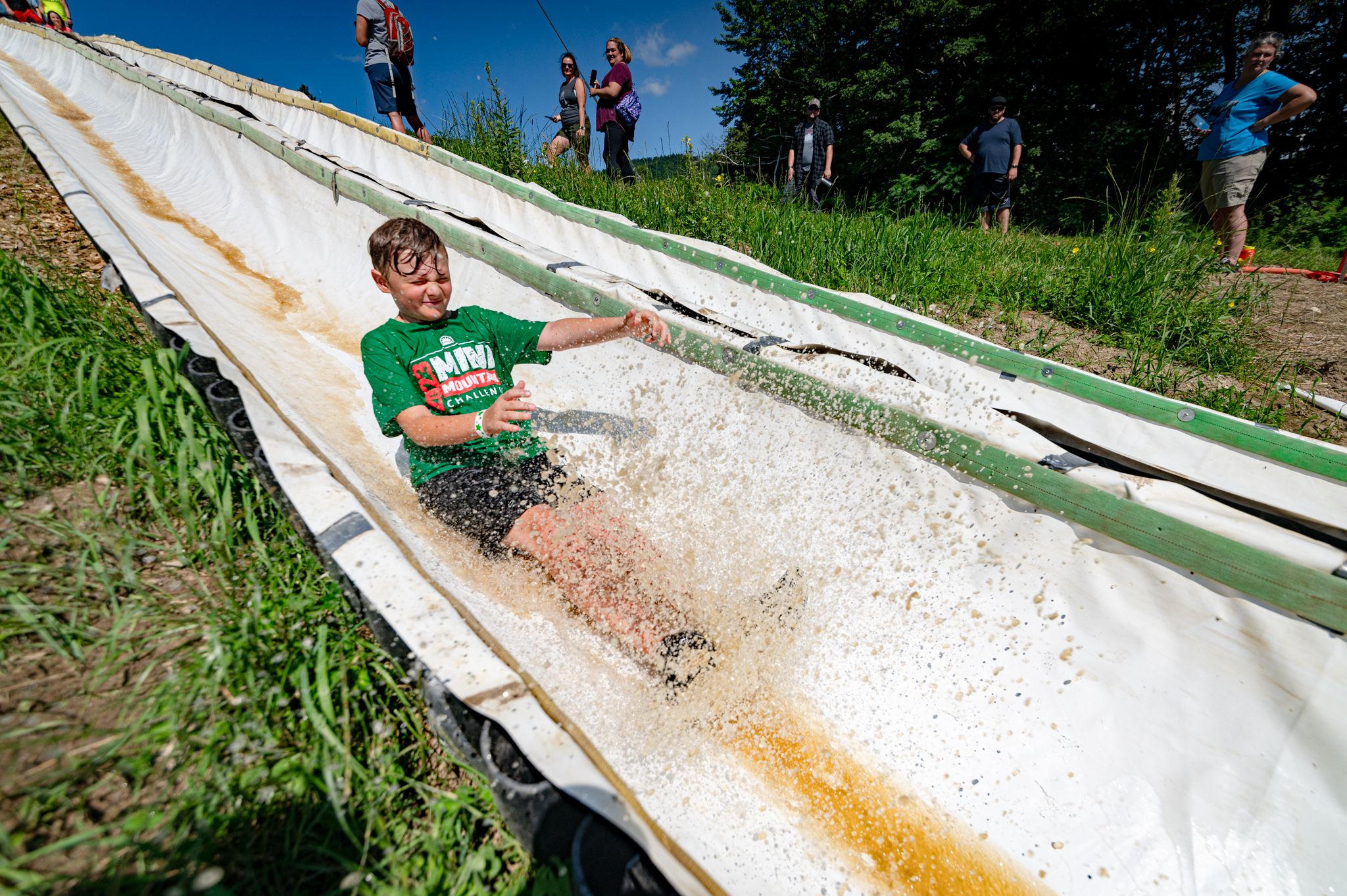 Mini Mountain Challenge competitor sliding on a waterslide.