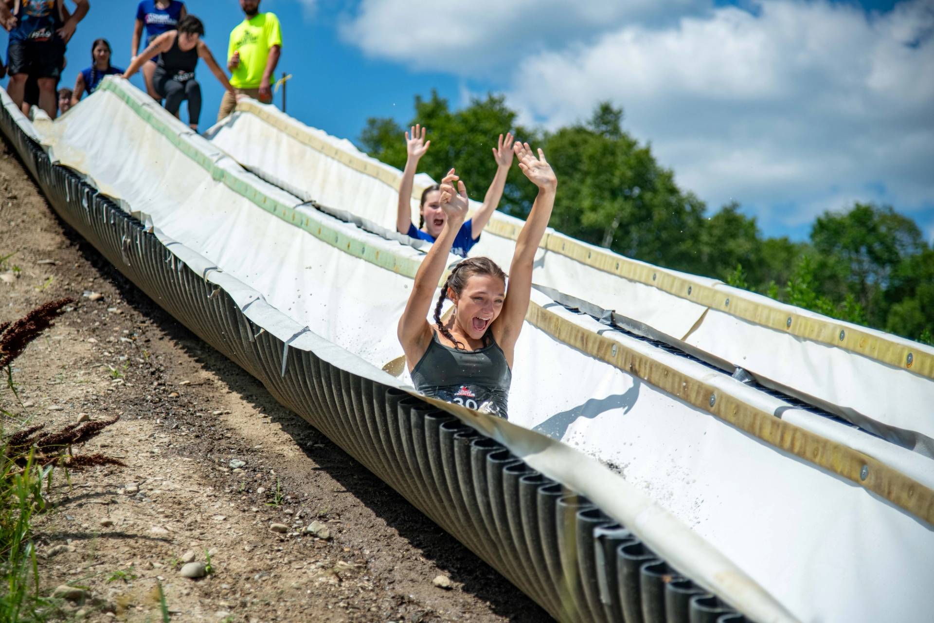 A person sliding down the water slide at Tough Mountain Challenge.