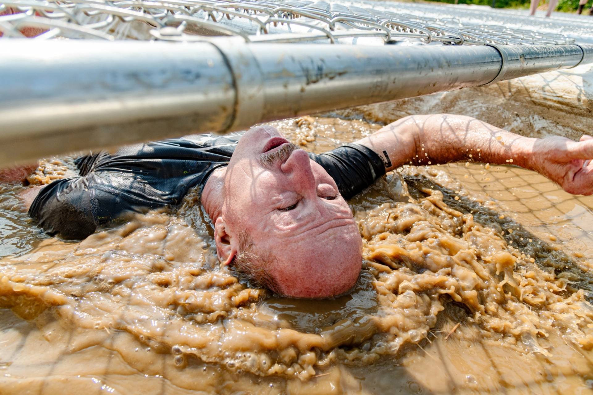 A man going through a muddle obstacle at Sunday River's Tough Mountain Challenge.