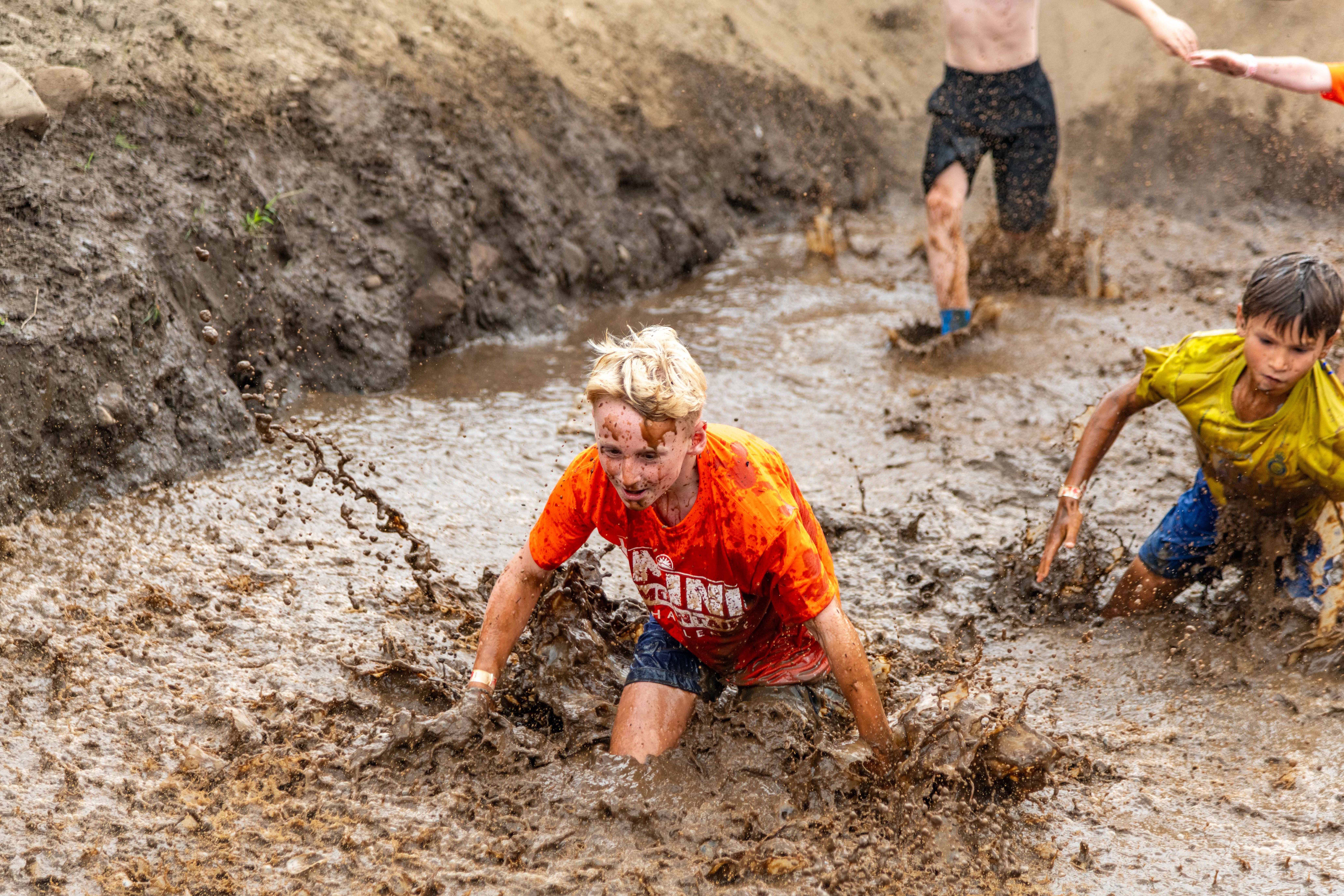 Mini Mountain racer splashing into the final mud pit obstacle.