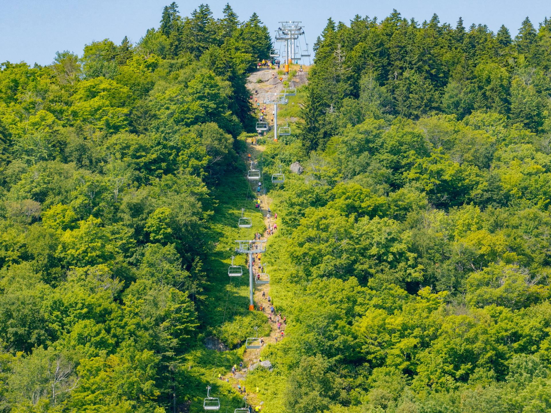 Athletes climbing up a super tall hill at Sunday River's Tough Mountain Challenge.