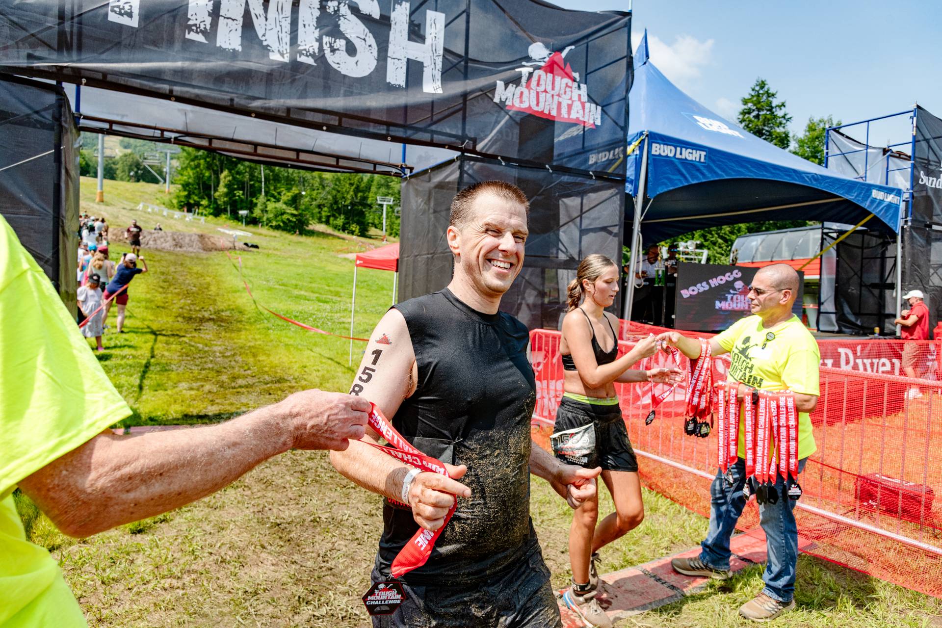 A man receiving his medal after finishing the Tough Mountain Challenge.