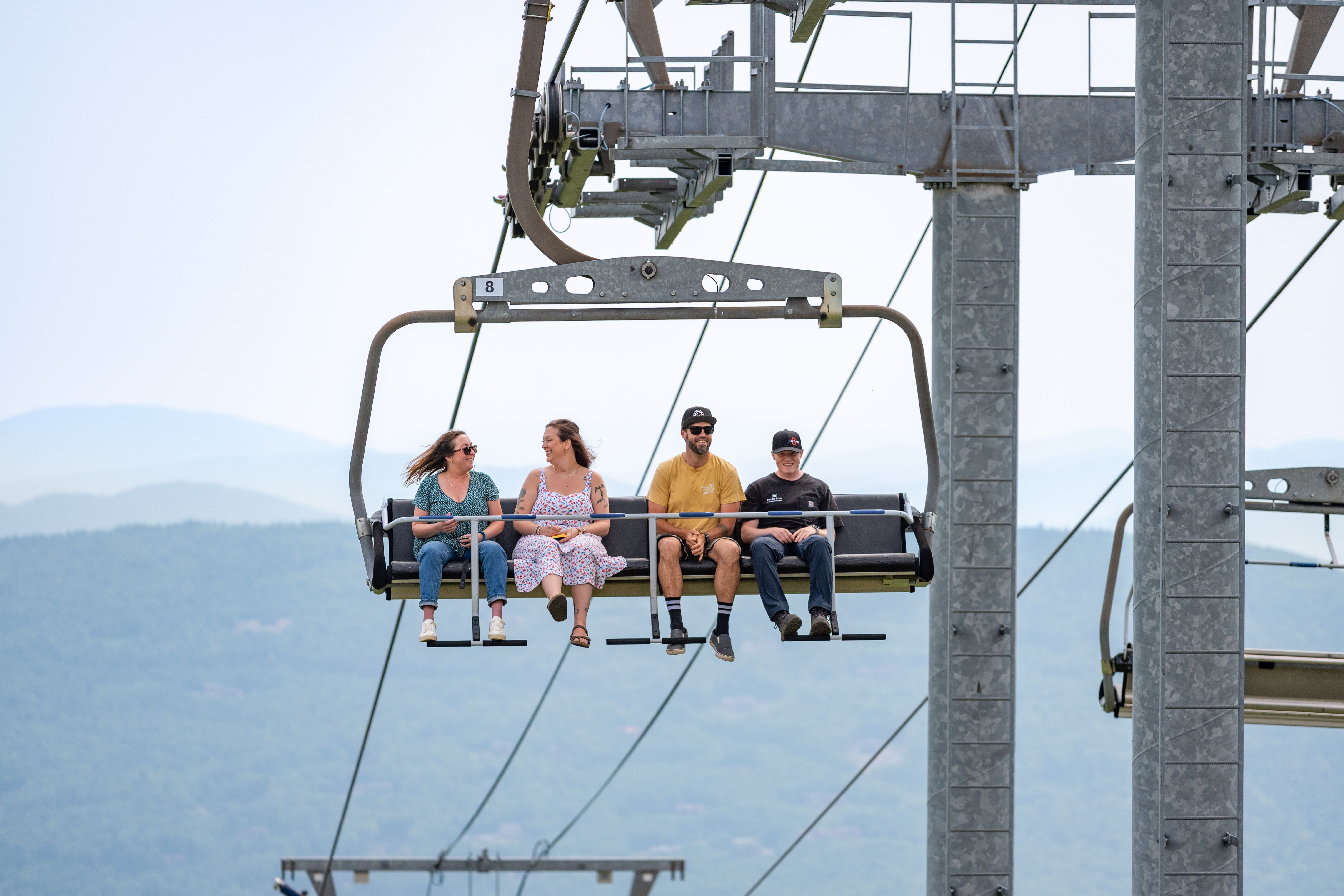 People taking a scenic lift ride at Sunday River in the summer.