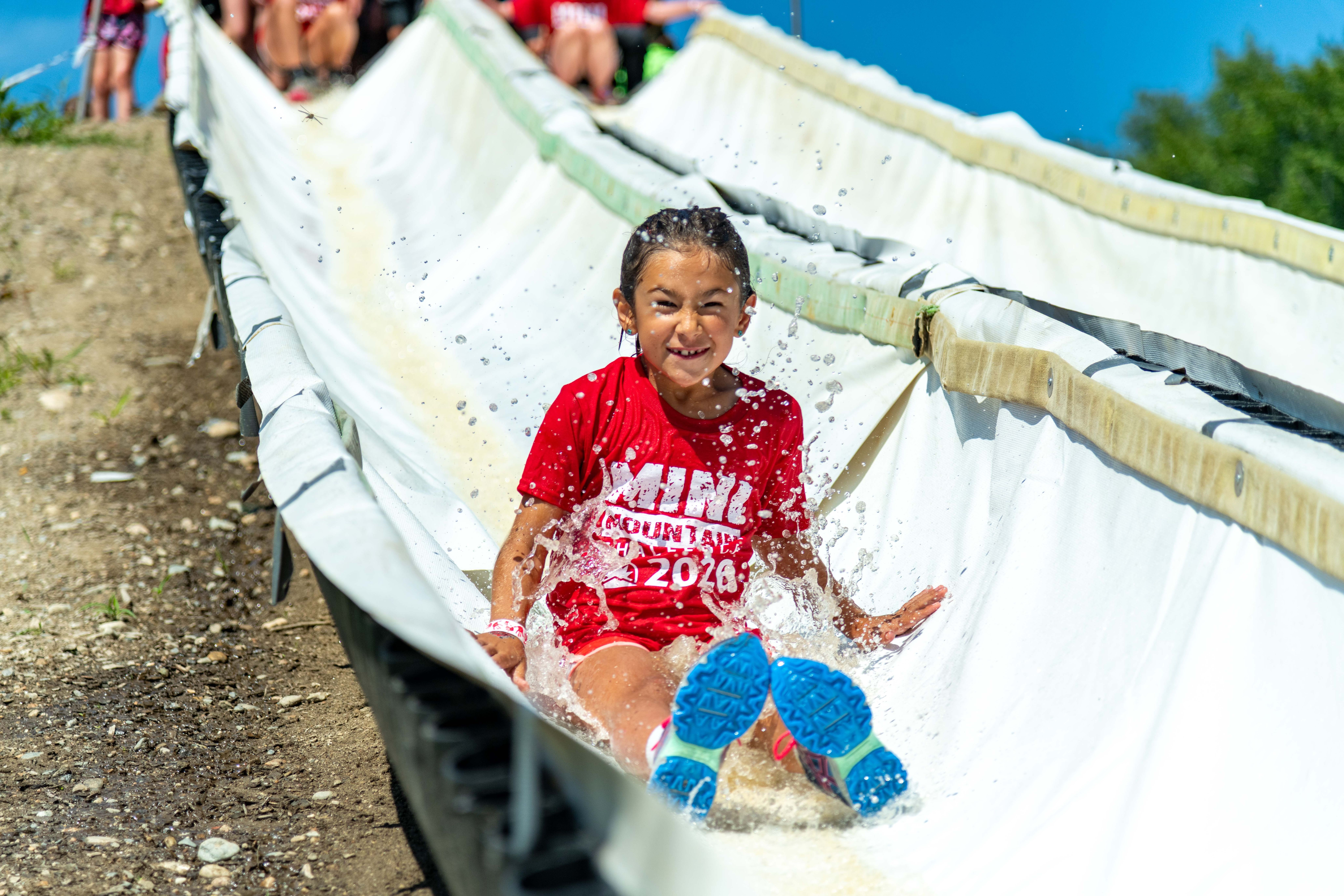 Mini Mountain Challenge competitor on the waterslide obstacle.