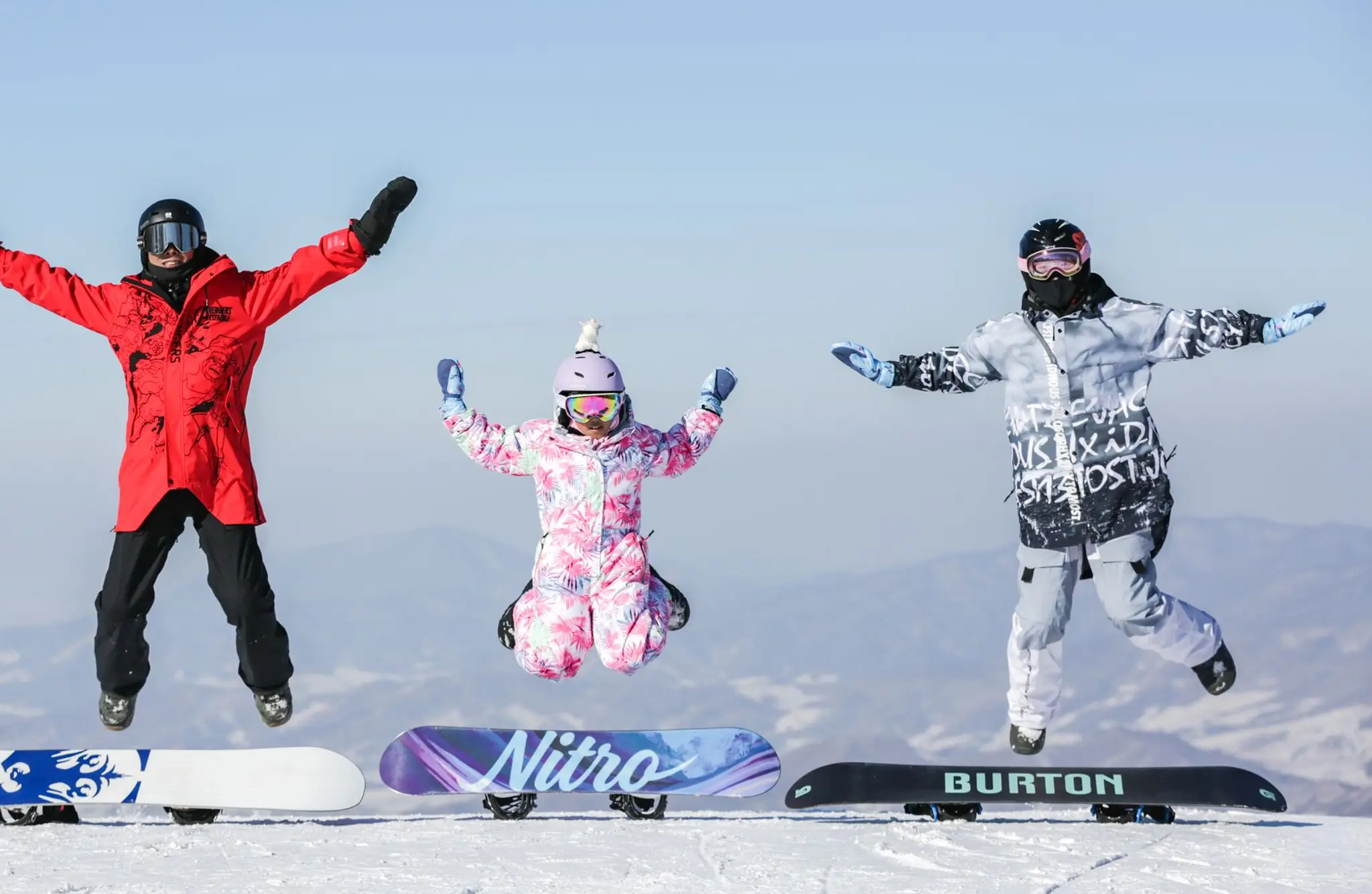 family jumping above snowboards