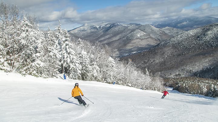 Two skiers descending a mountain trail.