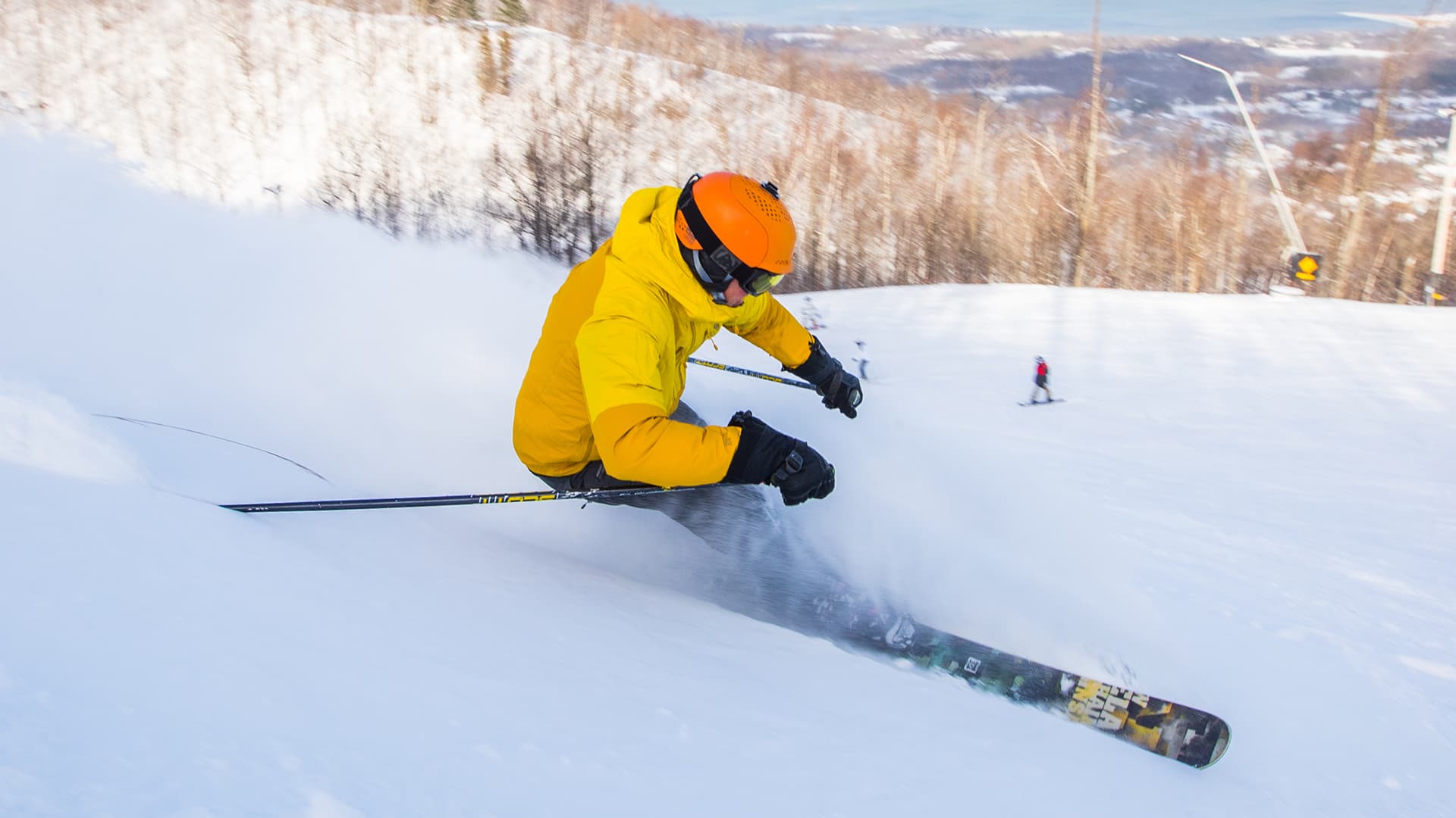 Action shot of skier leaving a cloud of powder behind as they navigate downhill.