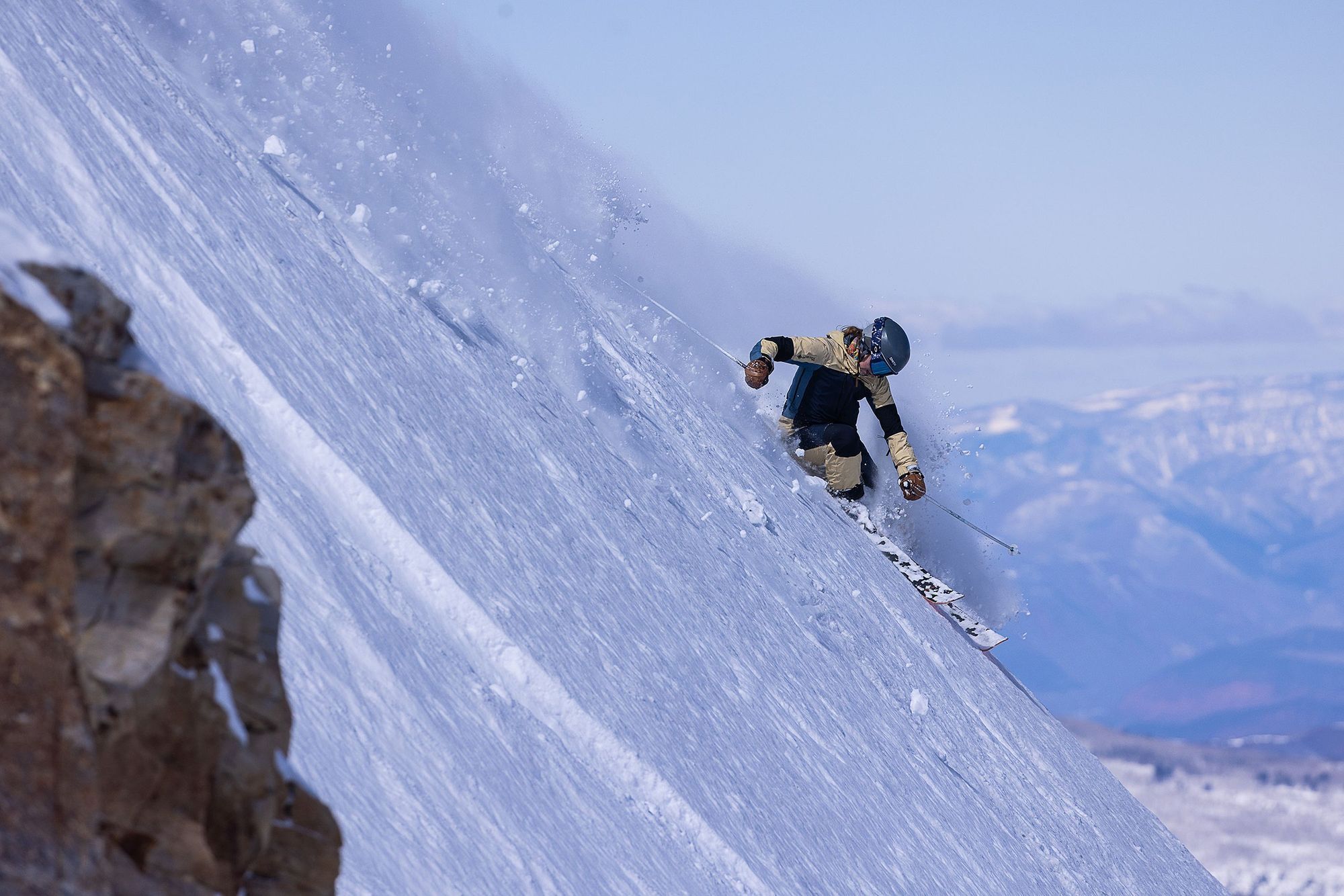 Skier going down a steep powder run.