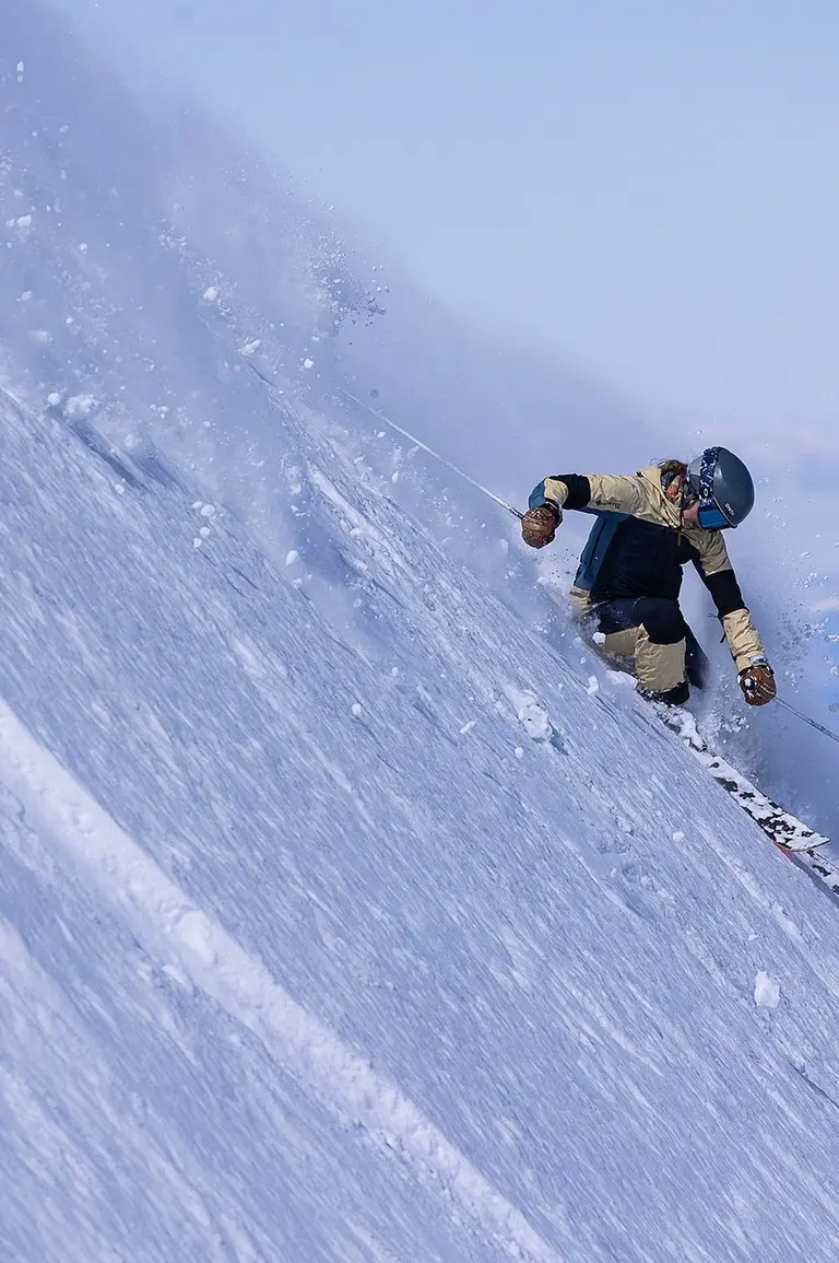 Skier going down a steep powder run.