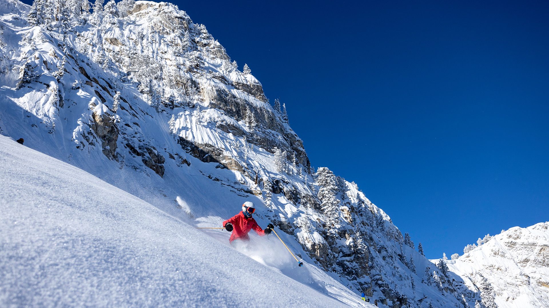 Skier enjoying powder in Honeycomb Canyon on a bluebird day