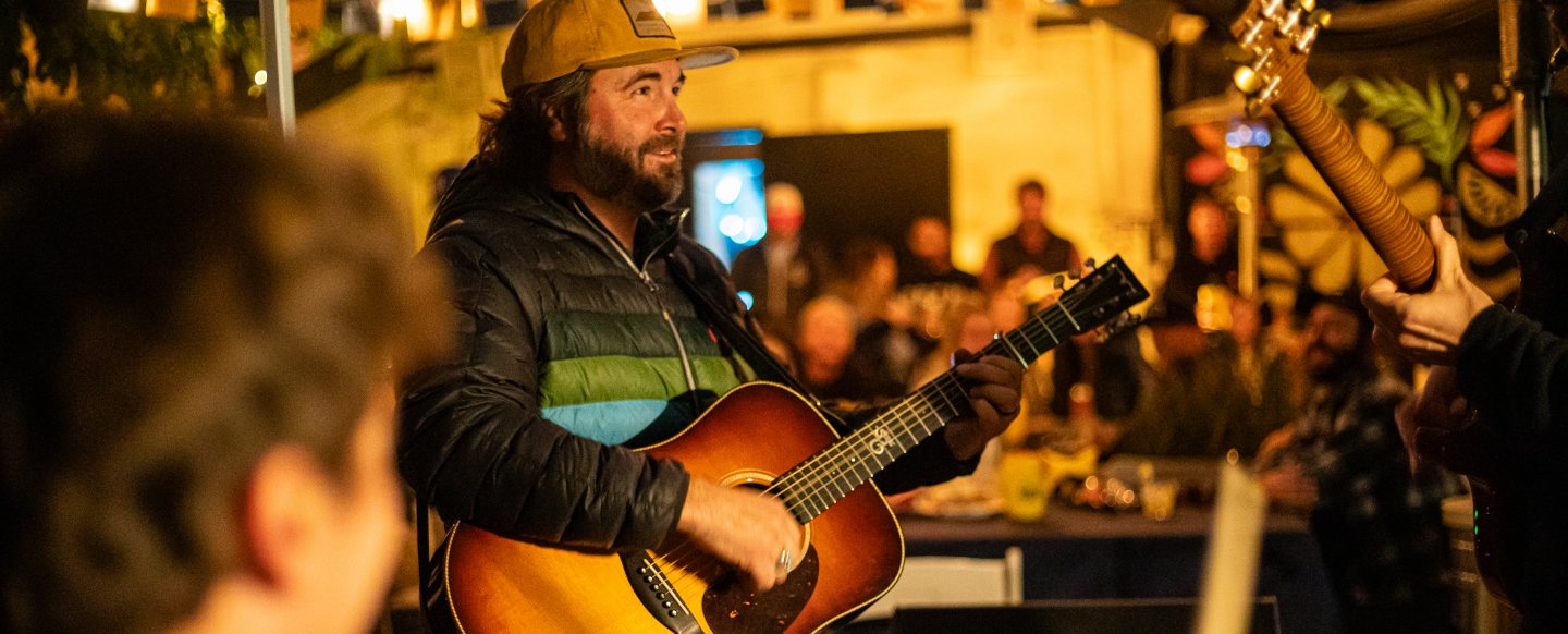 Person playing a guitar at a crowded event