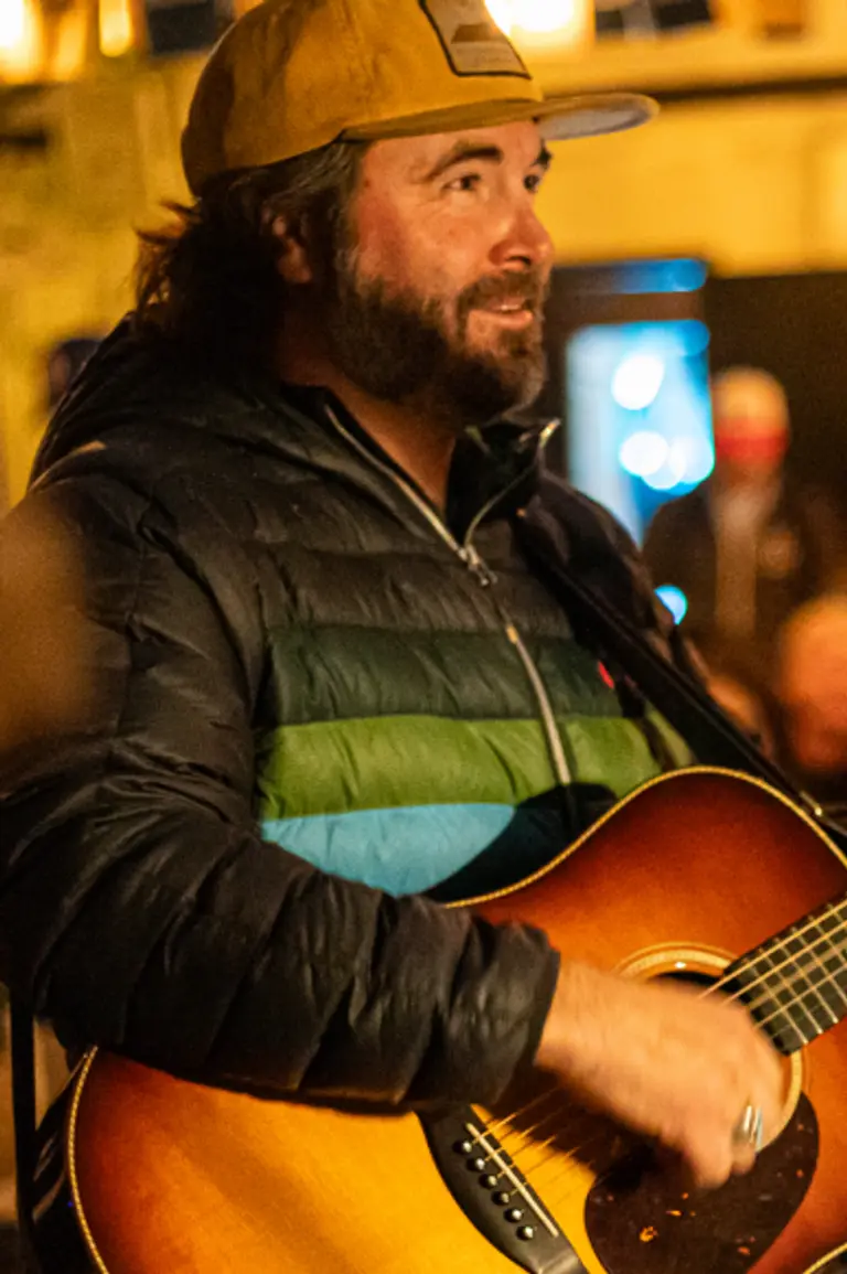 Person playing a guitar at a crowded event