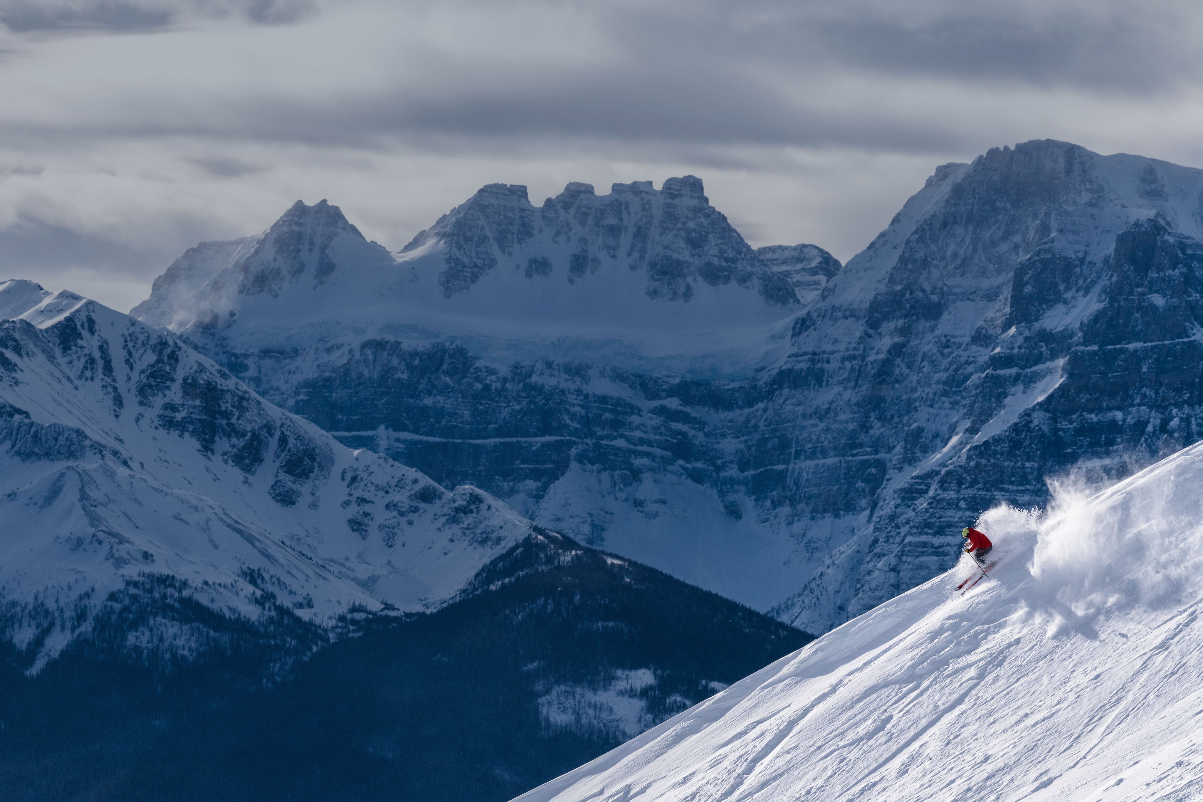 Skier going down a powdery mountain side