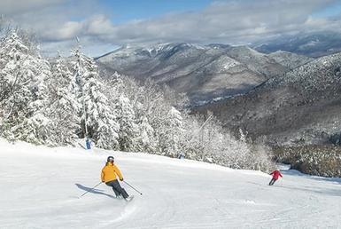 Two skiers descending a mountain trail.